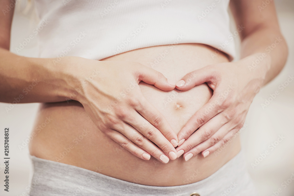 Close up. Pregnant Girl Shows Heart with her Hands