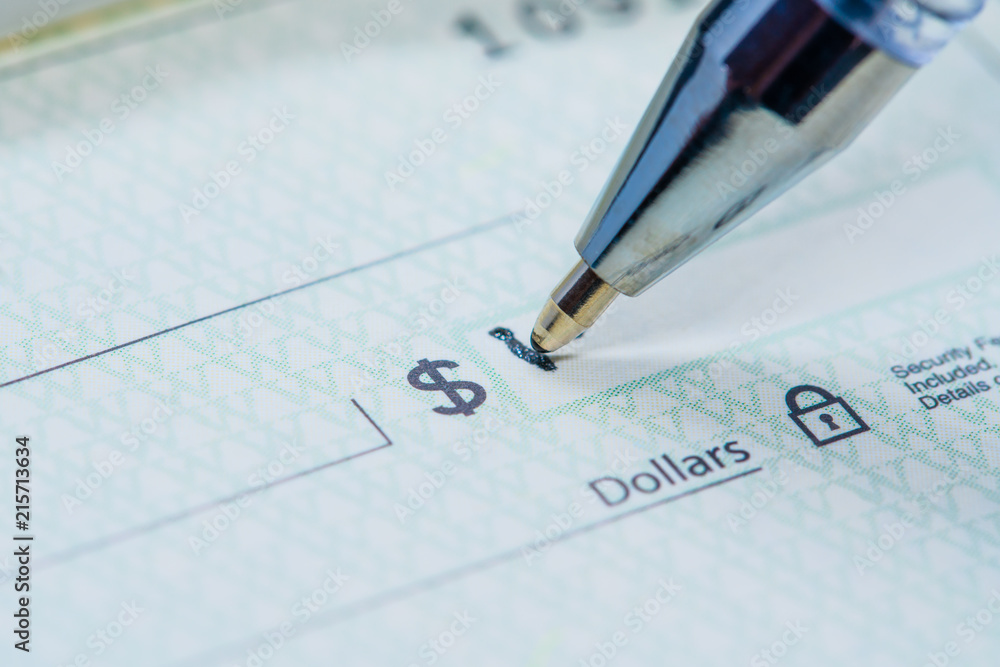 Black pen writing dollar amount on banking check Black pen writing dollar amount on banking check