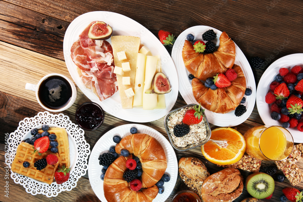 breakfast on table with waffles, croissants, coffe and juice.