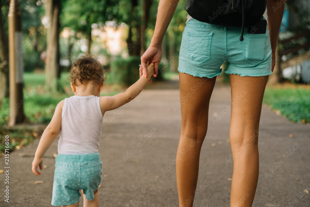 Mother with little daughter walking in the park