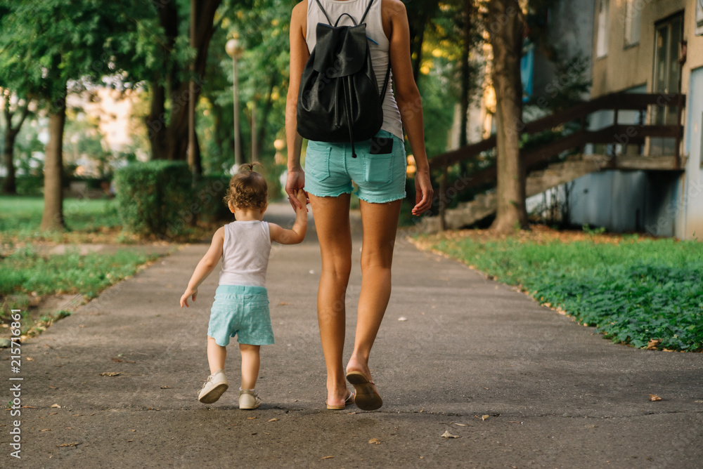 Mother with little daughter walking in the park