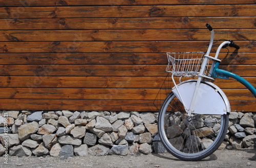 Parede de madeira com alicerce e pedras e uma bicicleta encostada na parede photo