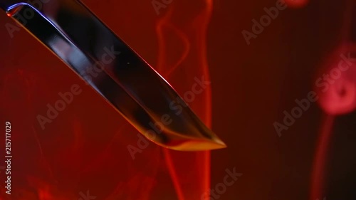 Blade of a knife close-up on a red background. Steel arms, Dagger. Blade close-up