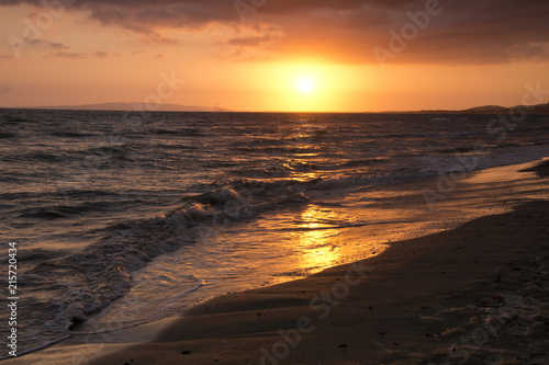 Tramonto sul mare con riflesso sulla spiaggia