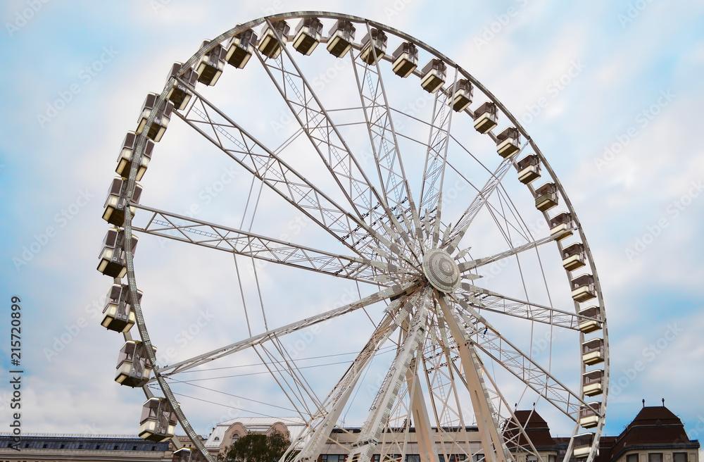 Large observation wheel on cloudy sky background