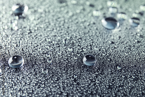 Many clean water drops on dark background