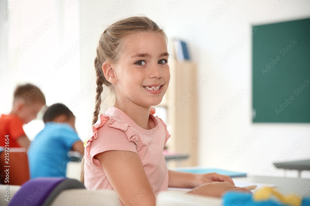 Cute little child sitting at desk in classroom. Elementary school Cute little child sitting at desk in classroom. Elementary school
