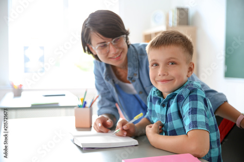 Female teacher helping child with assignment at school