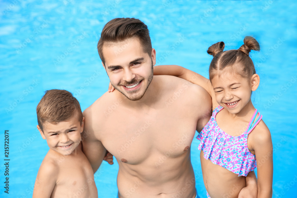 Young father with little children in swimming pool on sunny day Young father with little children in swimming pool on sunny day