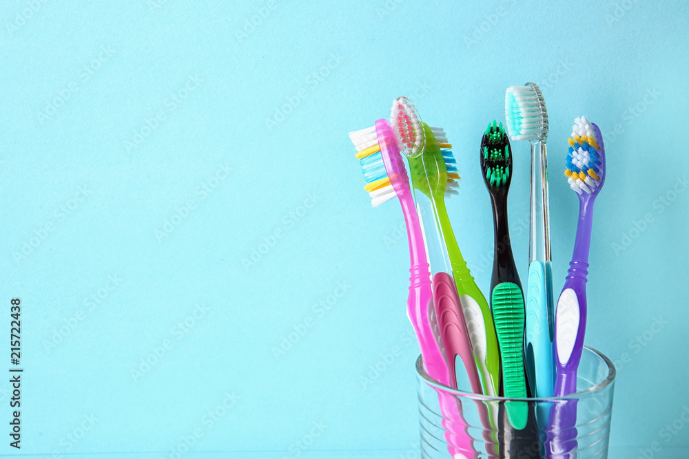 Cup with toothbrushes against color background. Dental care Cup with toothbrushes against color background. Dental care