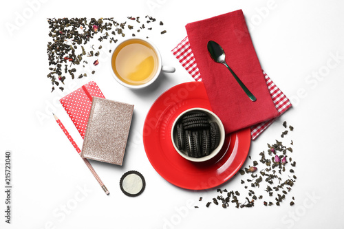 Flat lay composition with hot tea and cookies on white background