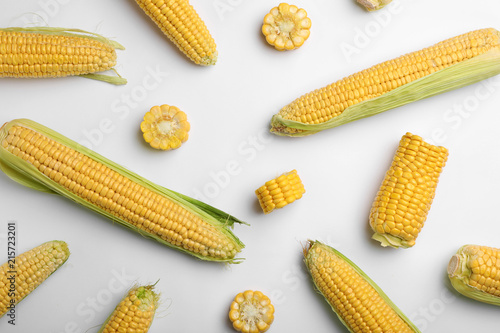 Flat lay composition with tasty sweet corn cobs on white background