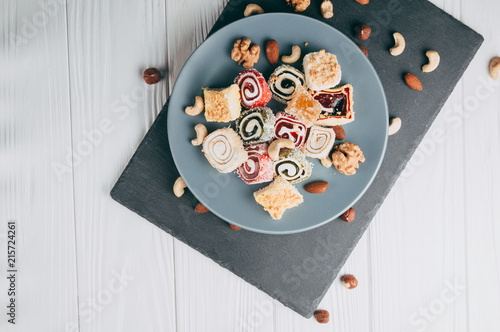 Bilde på lerret Traditional oriental sweets and nuts: hazelnuts, cashews on a white wooden background