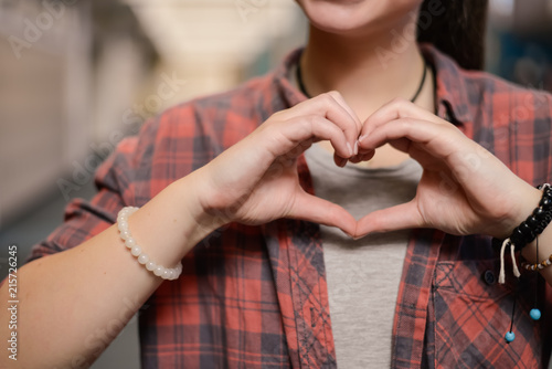 Teen girl showing heart hands at high school