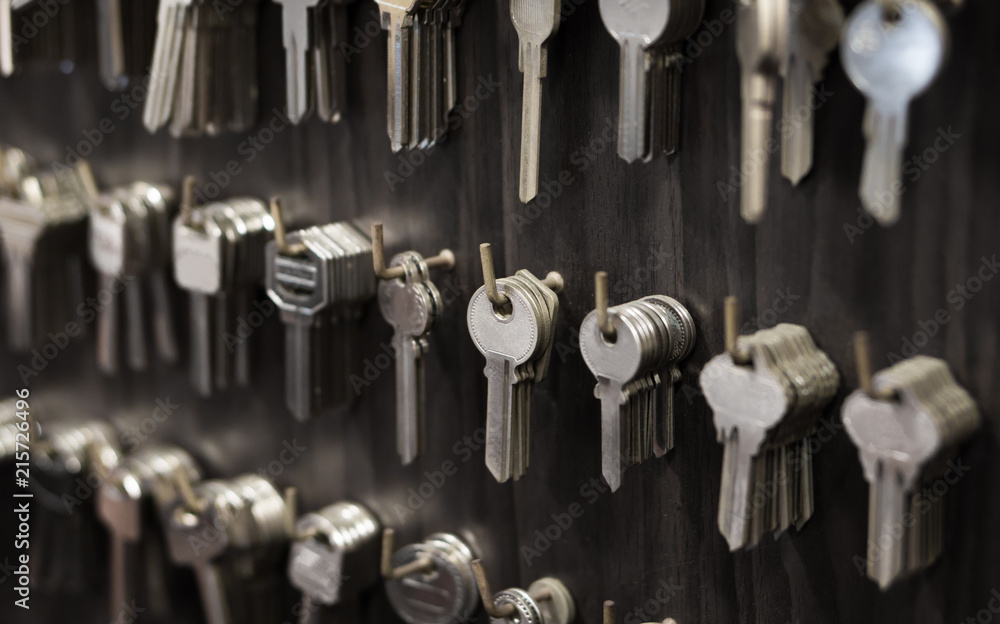 Several Keys type such as household and car key use for copying or duplicating hang on the wall in the locksmith workshop - obrazy, fototapety, plakaty 