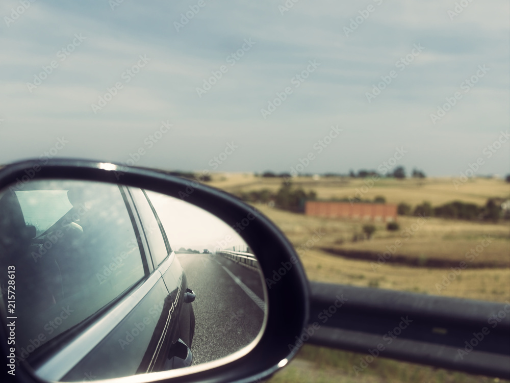 Car Trip. View of Side Mirror and Countryside in the Background (Vintage Style)