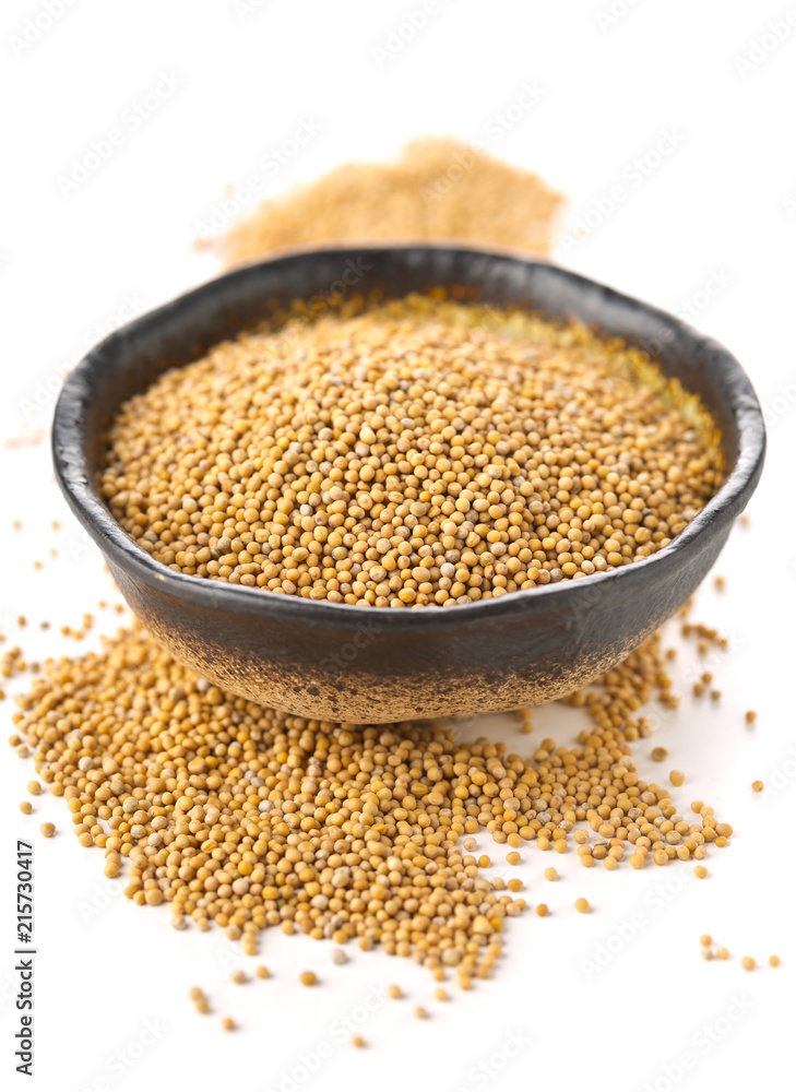 Heap of raw, unprocessed mustard seed kernels in bowl on white