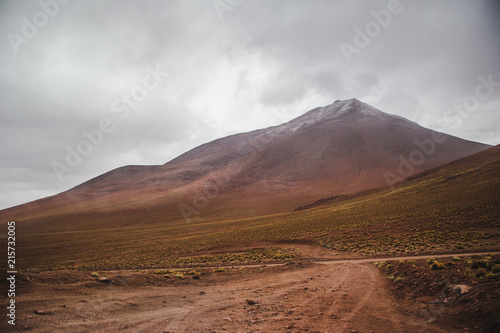 Dirt track leading to a mountain in the Eduardo Avaroa national park in Bolivia during rainy season