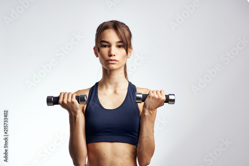 young woman doing fitness exercises with dumbbells