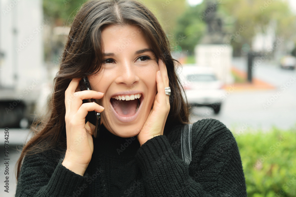 Portrait of a surprised woman talking on smart phone
