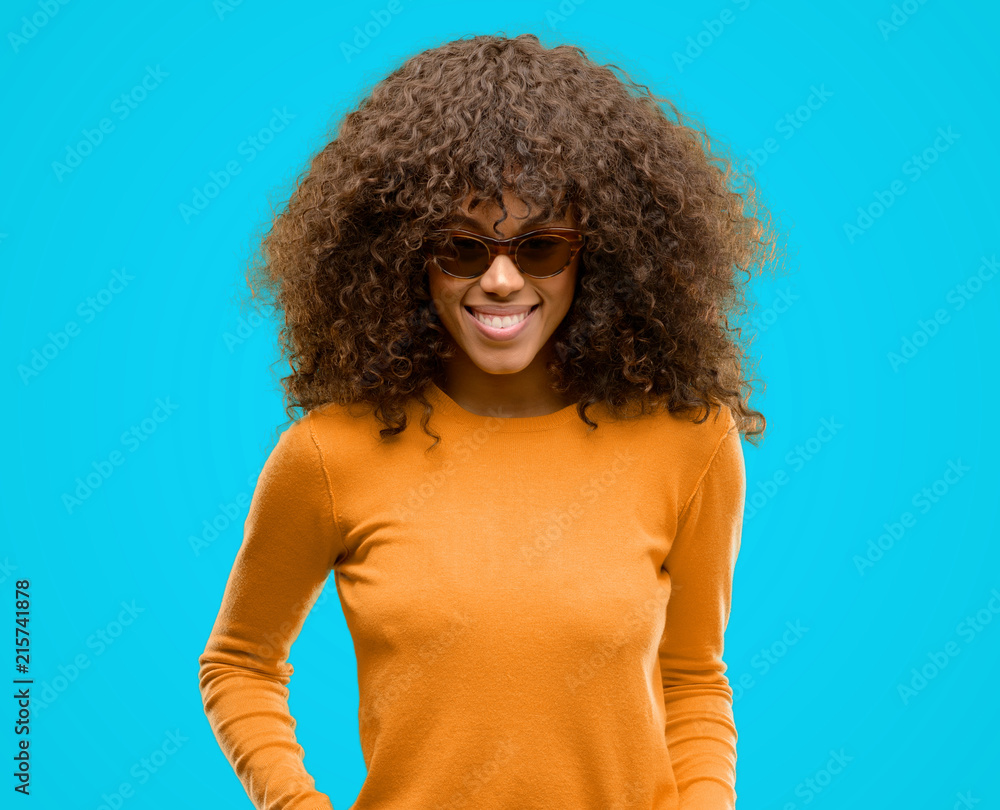 African american woman wearing an orage sweater with a happy face standing and smiling with a confident smile showing teeth African american woman wearing an orage sweater with a happy face standing and smiling with a confident smile showing teeth