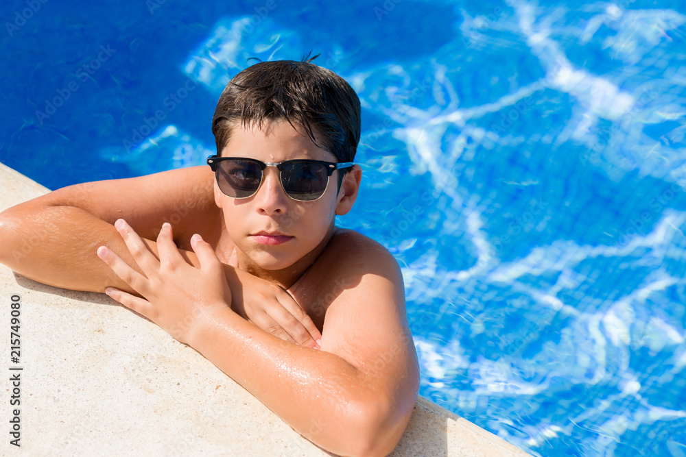 Young child on holiday at the swimming pool by the beach with a confident expression on smart face thinking serious