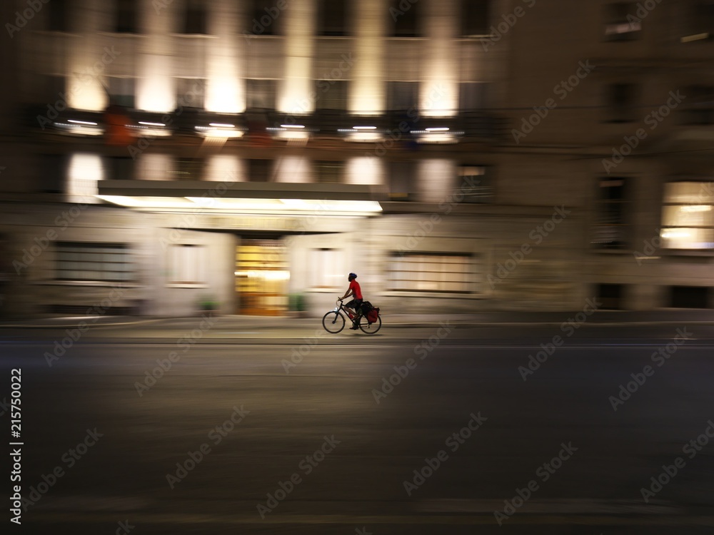 Rome,Italy-July 28, 2018: A man on a bike goes down Cavour street in the night Rome,Italy-July 28, 2018: A man on a bike goes down Cavour street in the night