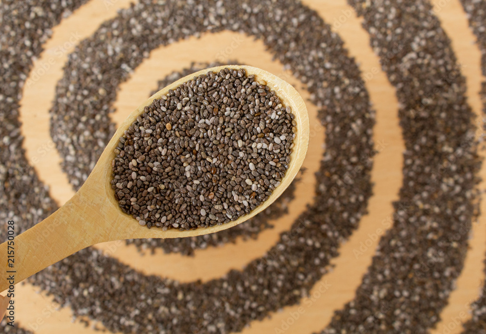 Healthy Chia seeds in a wooden spoon on a wooden table Healthy Chia seeds in a wooden spoon on a wooden table