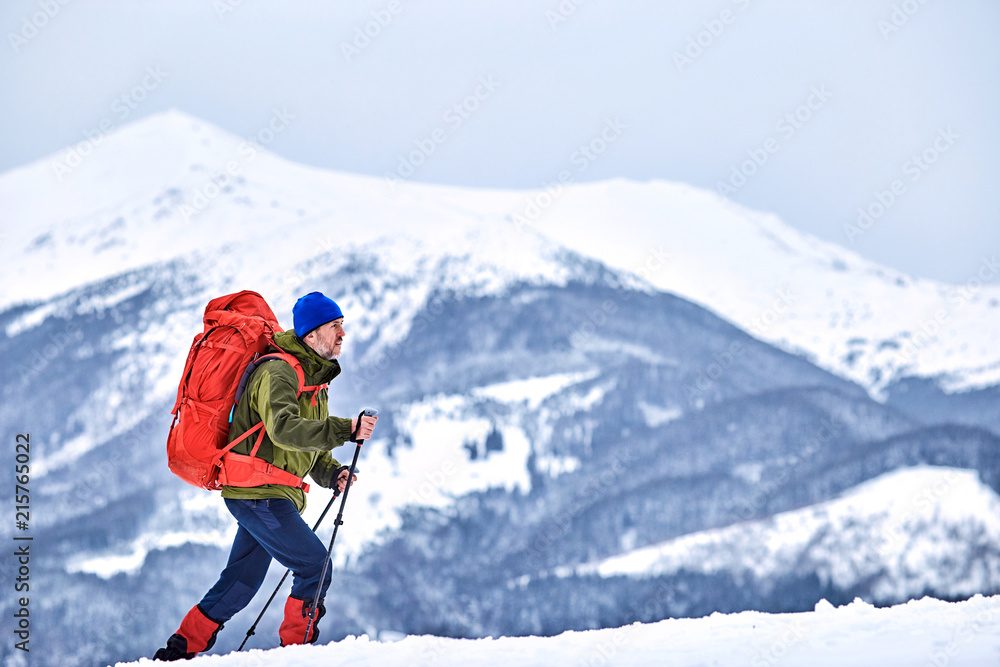 Winter climb to the top of the mountain with a backpack.