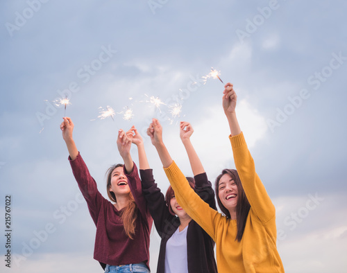 Happy group of asian girl friends enjoy and play sparkler at roof top party at evening sunset,Holiday celebration festive,teeage lifestyle,freedom and fun.