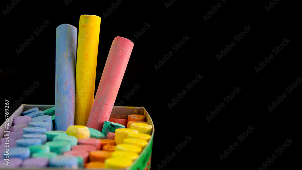 Fototapeta premium Multi color chalks on black background for copy space