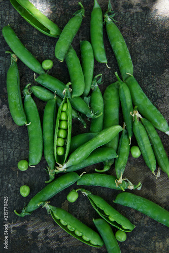 Fresh green peas in pods on a dark gray background. Rustic. Flat lay