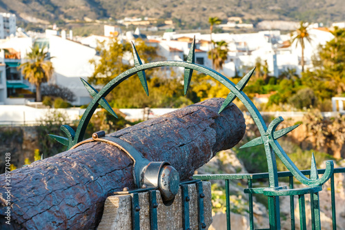 Seascape with ancient cannon on Playa Carabeillo beach in Nerja, Costa del Sol, Spain photo