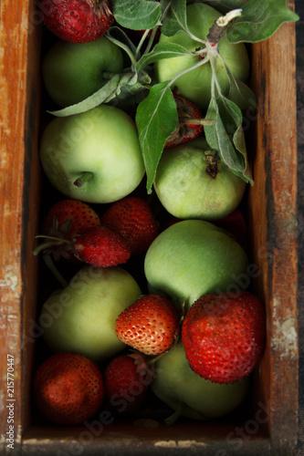 Fresh green apples and strawberry in a wooden box. Rustic. Flat lay