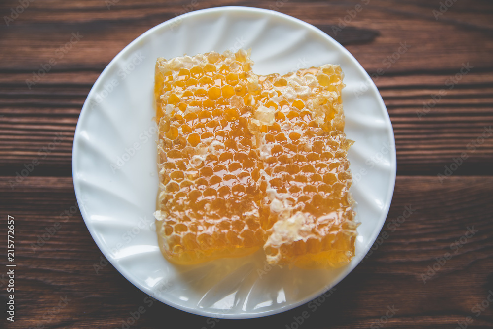 honey in honeycombs on a white plate honey in honeycombs on a white plate