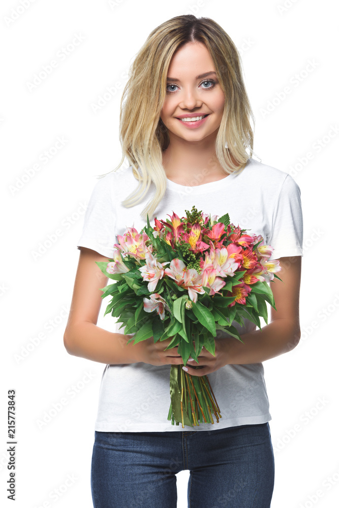 smiling attractive girl holding bouquet of flowers and looking at camera isolated on white