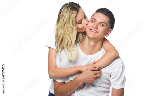 girlfriend kissing smiling boyfriend isolated on white