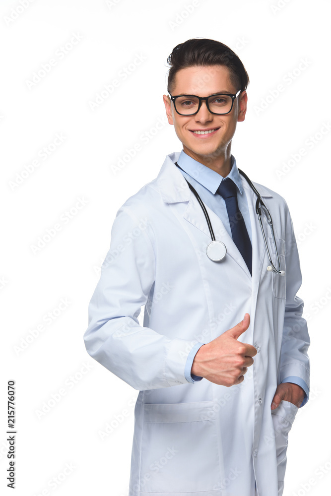 smiling young doctor showing thumb up and looking at camera isolated on white smiling young doctor showing thumb up and looking at camera isolated on white