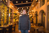 Young smiling man posing at night in cafe