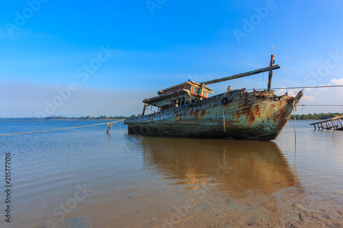 Fototapeta Naklejka Na Ścianę i Meble -  Broken and old fishing boat , Three Ship Wreck in Kuala Penyu, Sabah, Malaysia , Abandoned Ship at sabah borneo malaysia Image has grain or blurry or noise and soft focus when view at full resolution.