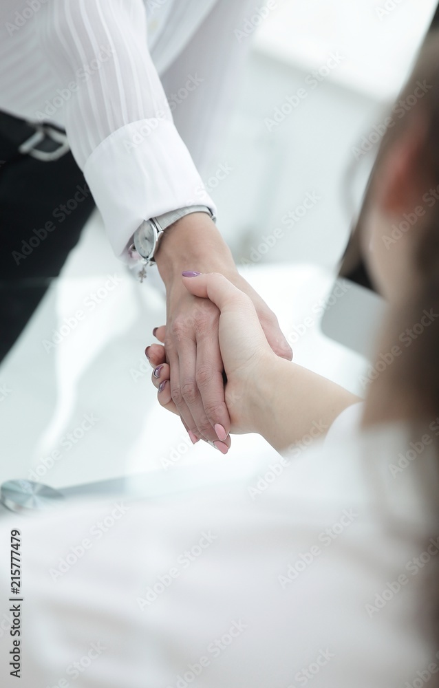 employees greet each other with a handshake near the desk