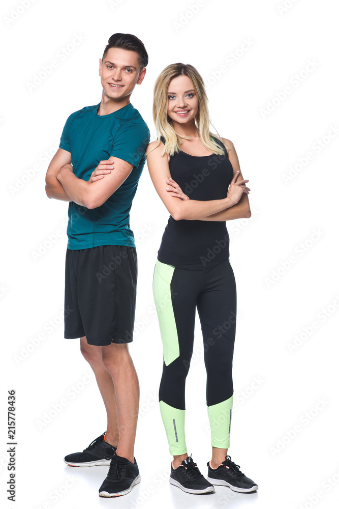 young fit couple with crossed arms looking at camera isolated on white young fit couple with crossed arms looking at camera isolated on white