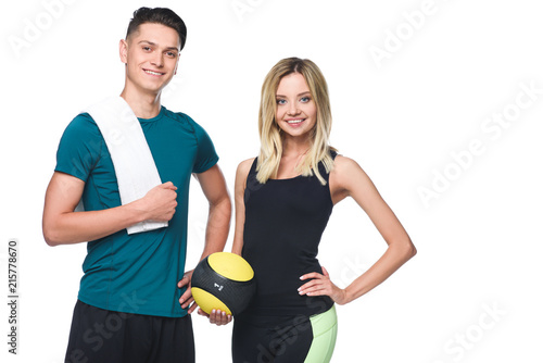 young sporty couple with fitball and towel looking at camera isolated on white