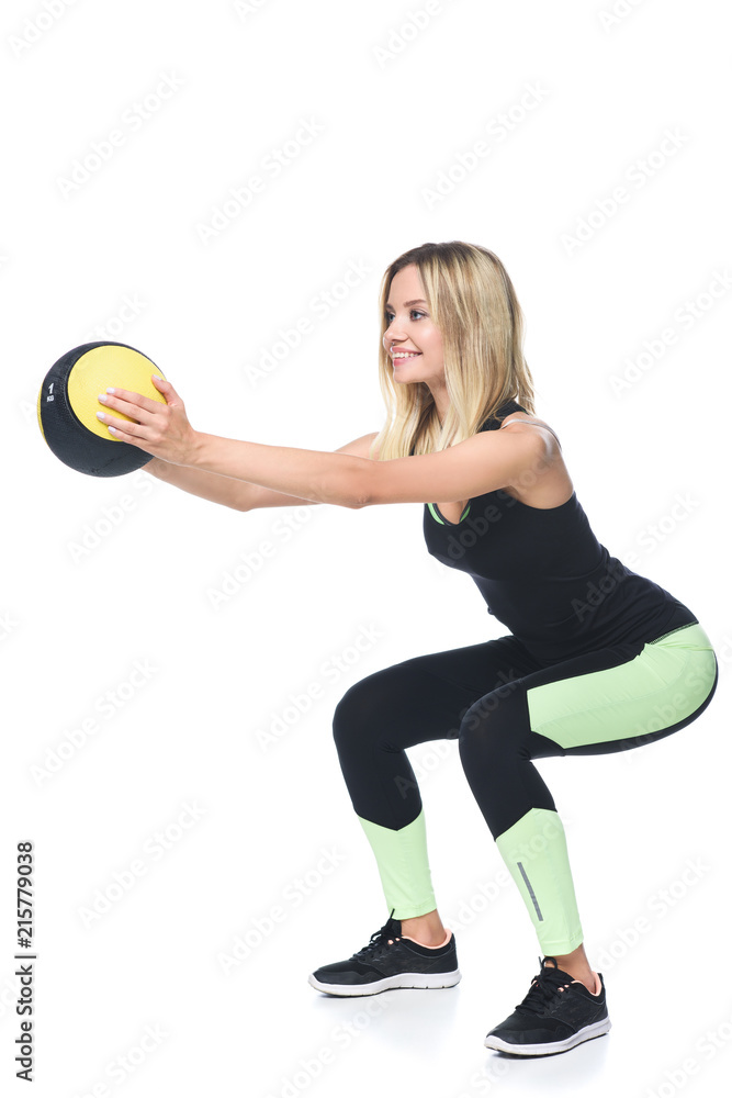 sporty young woman doing squats with medicine ball isolated on white