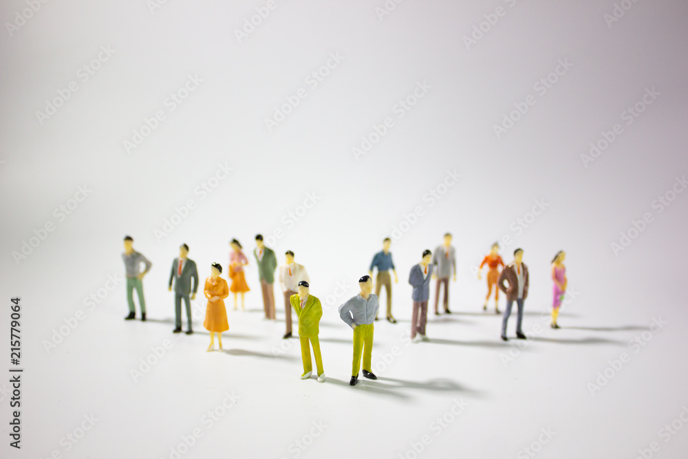 A big group of miniature business people stand on gray background. A big group of miniature business people stand on gray background.
