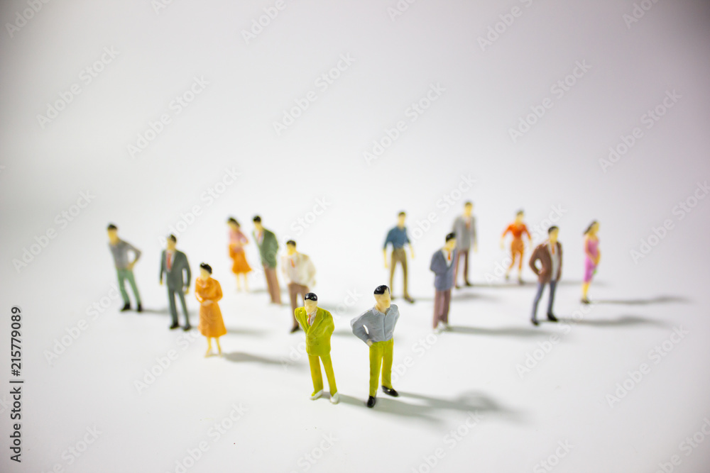 A big group of miniature business people stand on gray background. A big group of miniature business people stand on gray background.