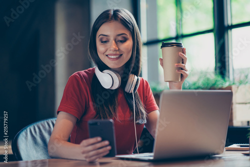 Canvas Print Straight-haired young smiling girl wearing casual red t-shirt, working remotely,