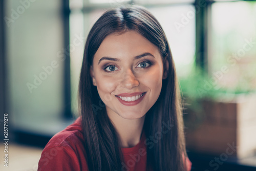 Canvas Print Close up portrait of young brunette girl who looks directly at the camera and sm