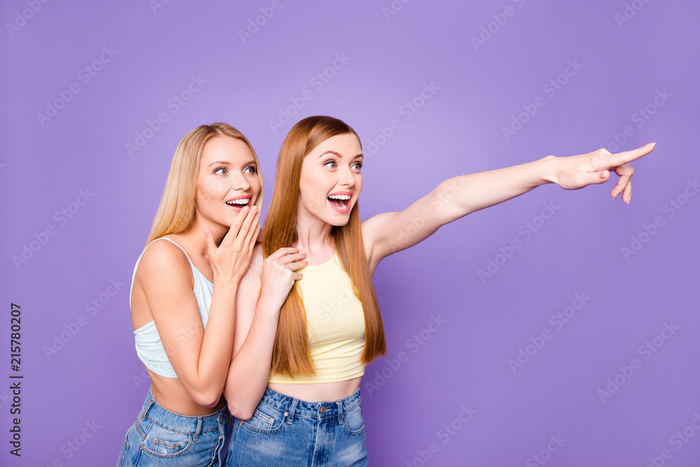 Advertisement rest relax leisure concept. Portrait of amazed glad girls watching away gesturing with forefinger isolated on violet background Advertisement rest relax leisure concept. Portrait of amazed glad girls watching away gesturing with forefinger isolated on violet background