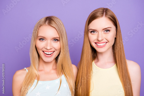Head shot portrait of cheerful positive girls with white healthy smile having long hair looking at camera isolated on violet background. Dental dentist stomatology concept